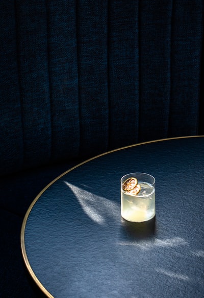 蓝色圆桌上有白色液体的透明酒杯
